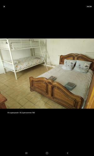 a bedroom with a wooden bed and a white bunk bed at Chambres dans gîte campagnard in Mers-sur-Indre