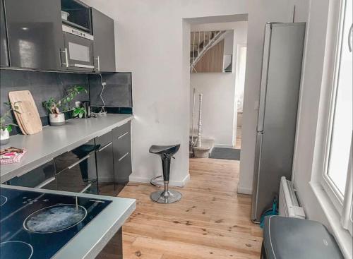 une cuisine avec un comptoir et un tabouret dans une pièce dans l'établissement Maison 7 personnes - Bordeaux, à Bordeaux