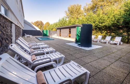 a row of white lounge chairs next to a building at Hunguest Hotel Apollo in Hajdúszoboszló