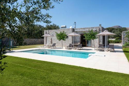 an external view of a villa with a swimming pool at Villa Liatiko with private pool in Atsipádhes