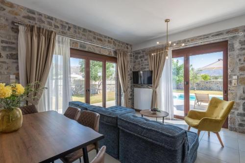 a living room with a blue couch and a table at Villa Liatiko with private pool in Atsipádhes