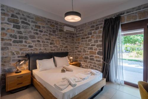 a bedroom with a bed and a brick wall at Villa Liatiko with private pool in Atsipádhes
