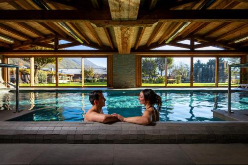 a man and woman sitting in a swimming pool at Agriturismo La Fiorida in Mantello