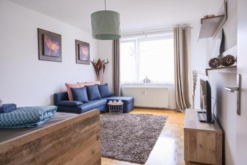 a living room with a blue couch and a tv at Angela Apartments in Würzburg
