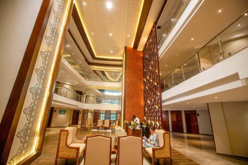 a lobby with a table and chairs and a large mirror at EZHIMALA AYURVEDA AND WELLNESS RESORT in Payyannūr