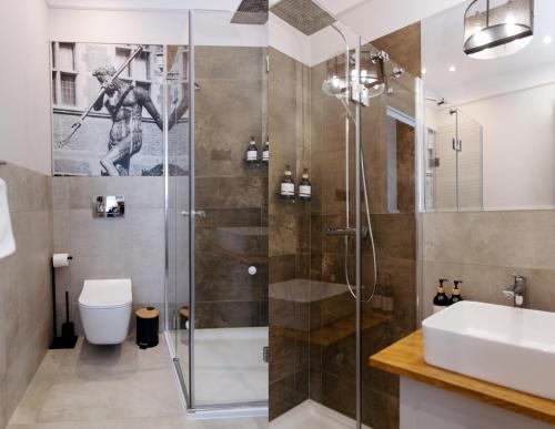 a bathroom with a shower and a toilet and a sink at Neptunus MB By the Ses Apartments OLD TOWN in Gdańsk