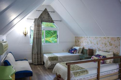 a attic room with two beds and a window at Boutique Villa on the Rocks with Stunning Sea Views, Infinity Pool & Private Sea in Trou dʼ Eau Douce