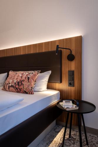 a bedroom with a bed and a table with a lamp at Hotel Alma Am Anger in Erfurt