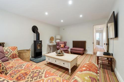 a living room with a couch and a wood stove at The Coachhouse, East Budleigh , Sleeps 4 in East Budleigh