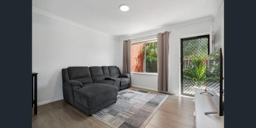 a living room with a couch and a chair at Holiday Rentals in Ascot Park
