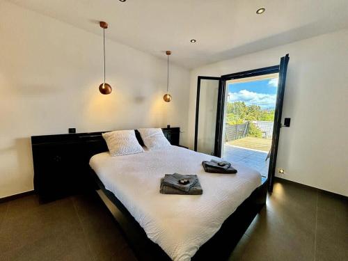une chambre avec un grand lit et une grande fenêtre dans l'établissement Casamea - Terrasse, Famille, Clim, Parking, à Ajaccio