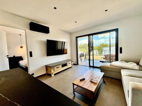 un salon avec un canapé et une table dans l'établissement Casamea - Terrasse, Famille, Clim, Parking, à Ajaccio