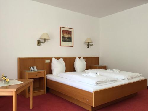 a hotel room with a bed and a table at gut-Hotel Pommernhotel Barth in Barth