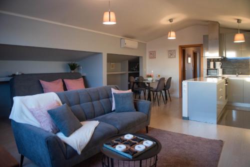 a living room with a blue couch and a kitchen at Viana Rooftop House - Apartment in the historic center with river view in Viana do Castelo