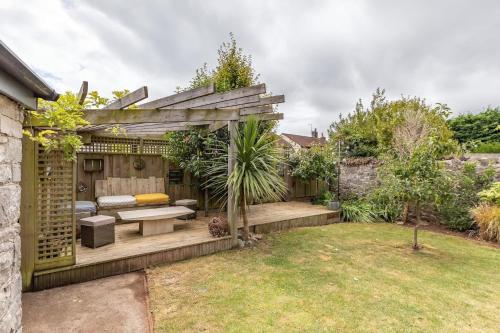 a garden with a bench and a pergola at Spacious House in the Heart of Cheddar in Cheddar