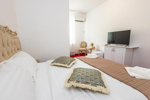 a bedroom with two beds and a flat screen tv at Boutique Boema in Târgovişte