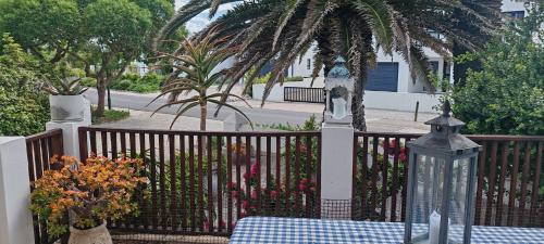 a wooden fence with a table and flowers on it at Concha at Shelley Point in Stompneusbaai