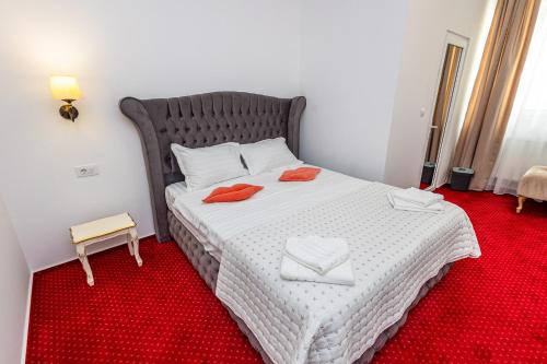 a bedroom with a bed with two towels on it at Boutique Boema in Târgovişte