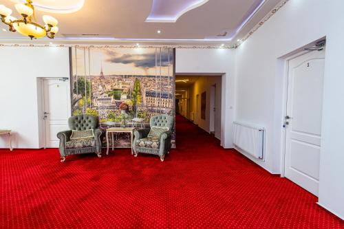 a room with a table and chairs on a red carpet at Boutique Boema in Târgovişte
