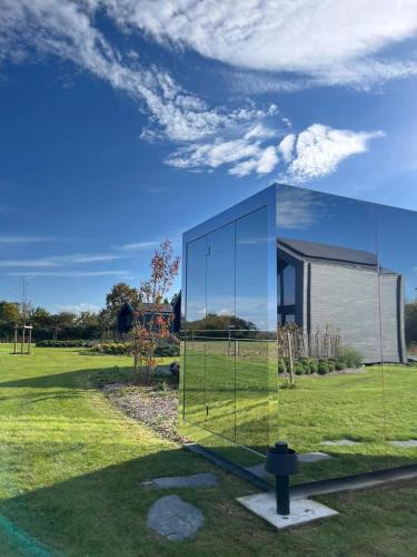 a glass house in a field with a building at Durbuy Insolite - Natural Escape in Durbuy