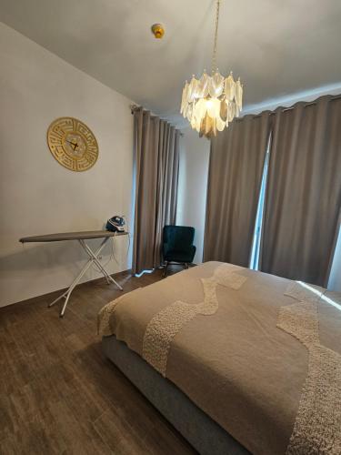 a bedroom with a bed and a table and a chandelier at Apartments 100 m2 in Sharjah