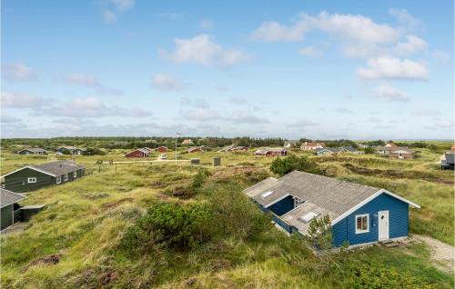 a blue house on a grassy hill with houses at Holiday Home Svenstibakkevej Ii in Lild Strand