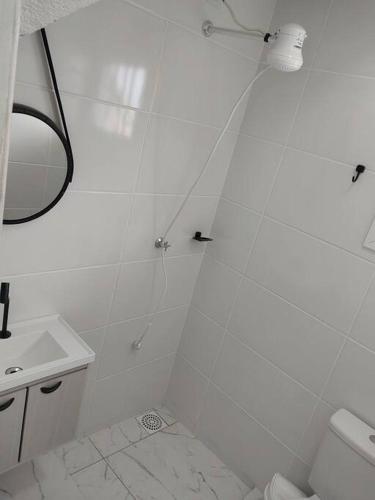 un bagno bianco con doccia e lavandino di Sobrado Novo 3 quartos a São Lourenço do Sul
