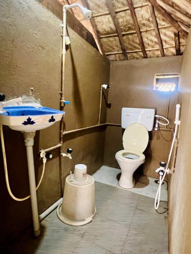 a bathroom with a sink and a toilet at Hippie Land Nature Stay in Hampi