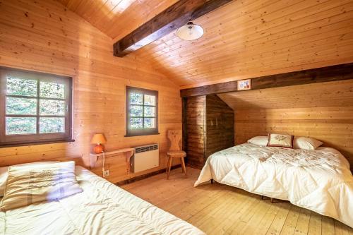 una camera da letto con un letto in una cabina di legno di CHALET SPA BELLE VUE 500 m des pistes a Manigod