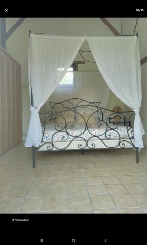a bed with a canopy in a room at Chambres dans gîte campagnard in Mers-sur-Indre