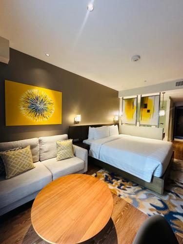 a hotel room with two beds and a couch at Hotel Residences near Makati in Manila