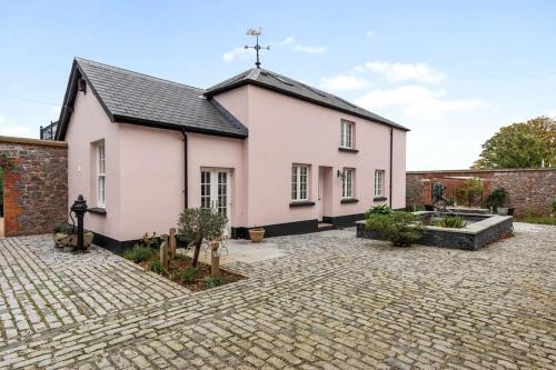 a white church with a cross on the roof at Coachmans Cottage, East Budleigh, Sleeps 6 in East Budleigh