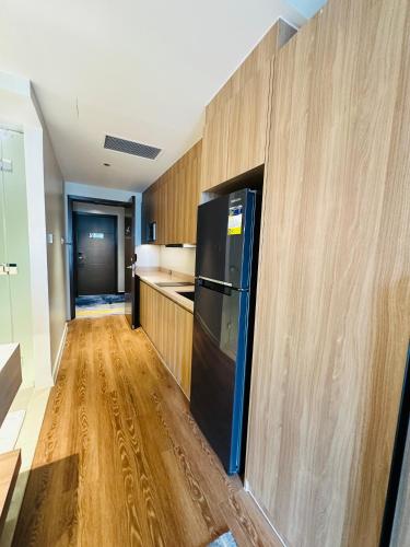 a kitchen with a black refrigerator and wooden walls at Hotel Residences near Makati in Manila