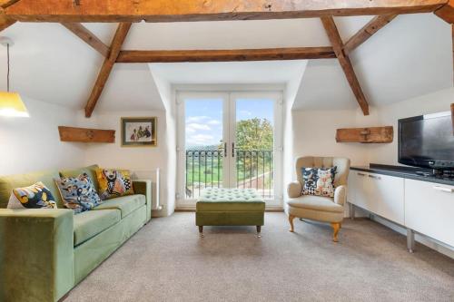 a living room with a green couch and a tv at Coachmans Cottage, East Budleigh, Sleeps 6 in East Budleigh