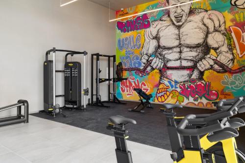 a gym with a painting of a man on the wall at Truliving Vallecas by Habyt in Vallecas