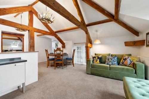 a living room with a green couch and a table at Coachmans Cottage, East Budleigh, Sleeps 6 in East Budleigh