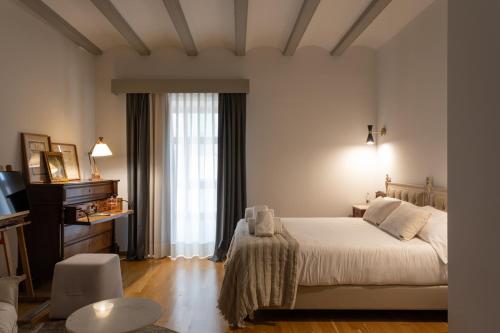 a bedroom with a white bed and a window at Hotel Palacio Barón de Andilla in Valdealgorfa