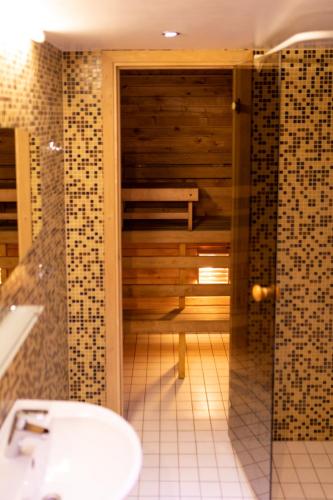 a bathroom with a shower with a toilet and a sink at Embrace Hotel & Apartments in Pärnu