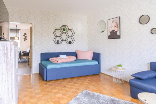 a living room with a blue couch with a pink pillow at Angela Apartments in Würzburg