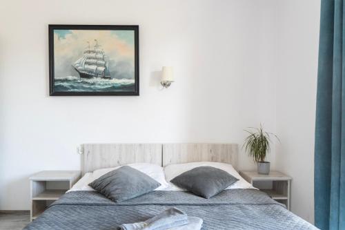 a bedroom with a bed with a painting on the wall at Jastra-Bay in Jastarnia