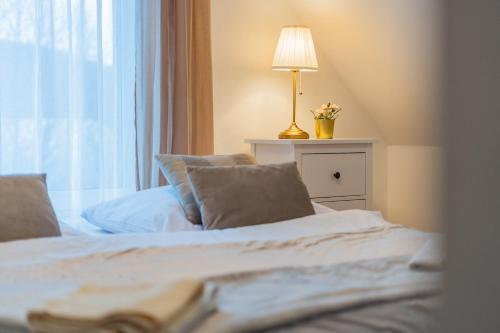 a bedroom with a bed with a lamp and a window at Wellness Apartmány Vila Republika in Velké Losiny