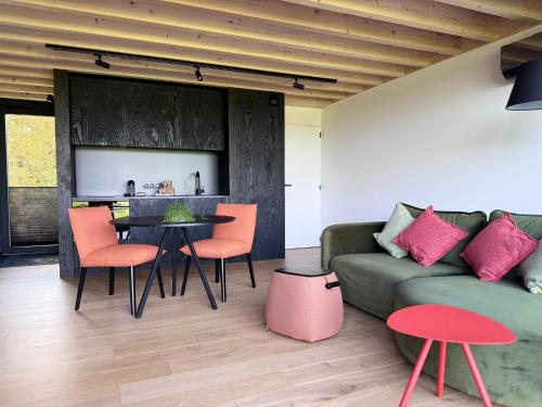 a living room with a couch and a table and chairs at Durbuy insolite - Romantic Escape in Durbuy