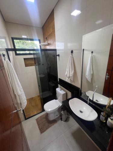 a bathroom with a toilet and a sink and a shower at Sobrado confortavel e central in Foz do Iguaçu