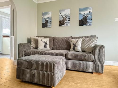 a living room with a couch and a chair at House In The Highlands in Fort William