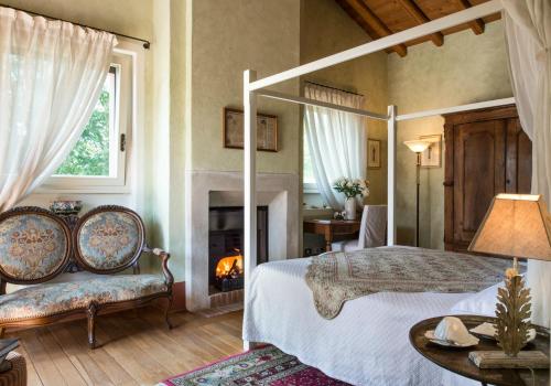 a bedroom with a canopy bed and a fireplace at San Giacomo Horses & Agriturismo in Arluno