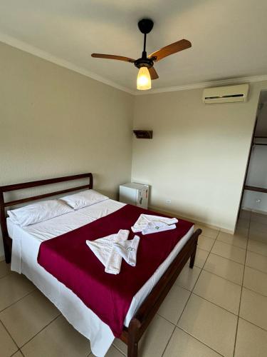 a bedroom with a bed with a ceiling fan at Pousada Marcondes in Paraty