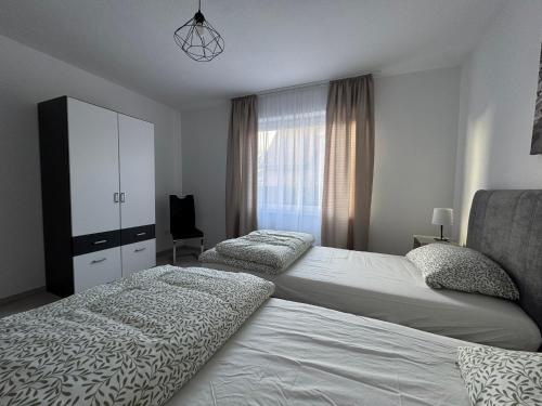 a bedroom with two beds and a cabinet and a window at Rheiner WohlfühlSuite mit Garten in Rheine