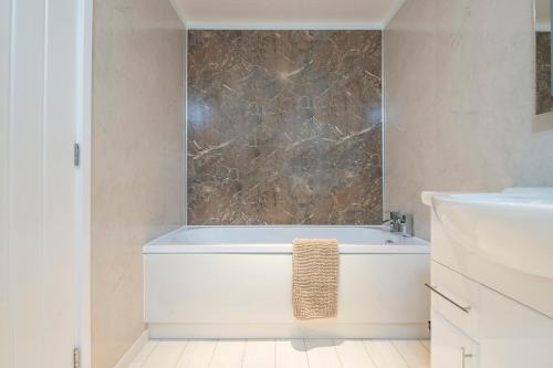 a bathroom with a white tub and a sink at Hafod Y Coed Lodge in Narberth