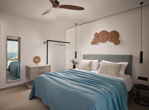 a bedroom with a bed and a ceiling fan at Askos Luxury Suites, a Zakynthian Hideaway, By ThinkVilla in Agios Nikolaos