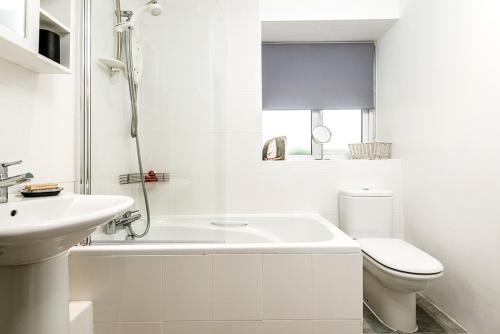 Un baño blanco con inodoro y lavabo. en Felin Fach, en Haverfordwest